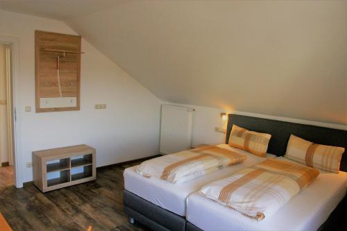 a bedroom with a large white bed in a room at Pension Weinig in Gersfeld