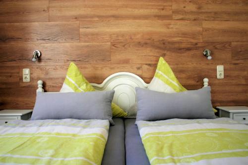 a bedroom with two beds and a wooden wall at Pension Weinig in Gersfeld