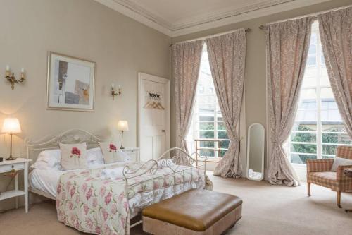 a bedroom with a bed and a chair and windows at ALTIDO Heart of Edinburgh Gem in Edinburgh