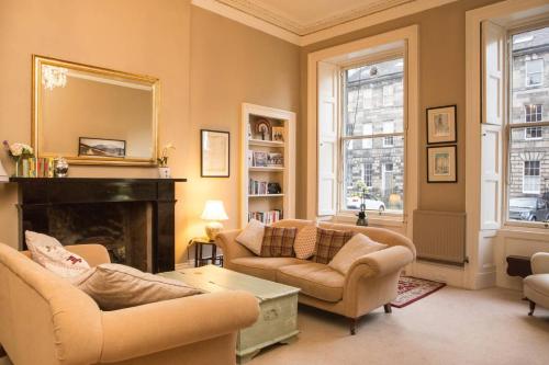a living room with two couches and a fireplace at ALTIDO Heart of Edinburgh Gem in Edinburgh