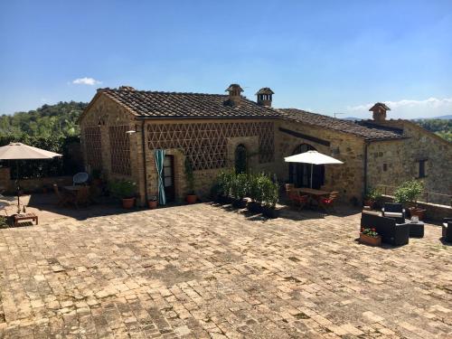 a large brick building with umbrellas and a patio at Case Nell' Aia in Poggibonsi