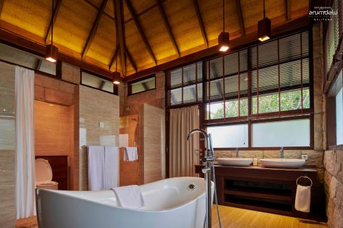 a bathroom with a tub and two sinks at Arumdalu Private Resort in Membalong