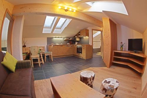 a living room and kitchen with a vaulted ceiling at Familien-Bauernhof Neumoar in Sankt Johann im Pongau