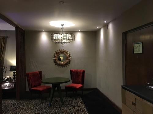 a room with a table and two chairs and a mirror at Radisson Blu Hotel MBD Ludhiana in Ludhiana