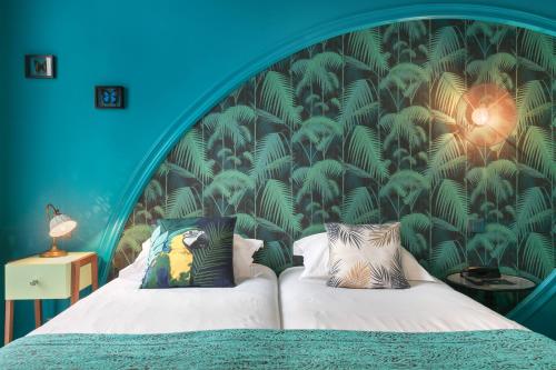 a bedroom with a bed with a blue wall at Villa Bougainville by Happyculture in Nice