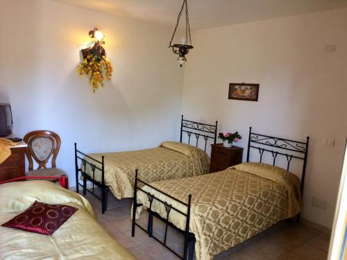a bedroom with three beds and a chandelier at Affittacamere Varone in Montaquila