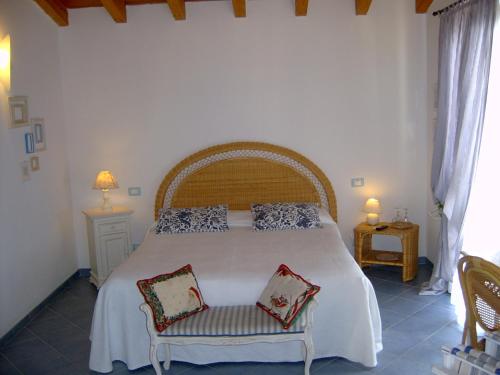 una camera da letto con un grande letto bianco con due sedie di Casa Lorenza a Riomaggiore