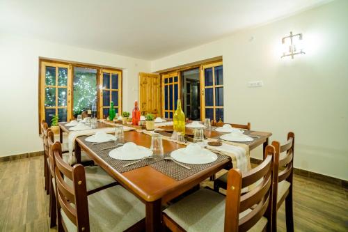 a dining room with a large wooden table and chairs at Aaramgah in Nārkanda
