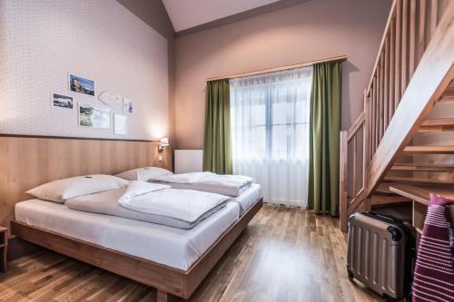 ein Schlafzimmer mit einem großen Bett und einer Treppe in der Unterkunft JUFA Hotel Grundlsee in Grundlsee