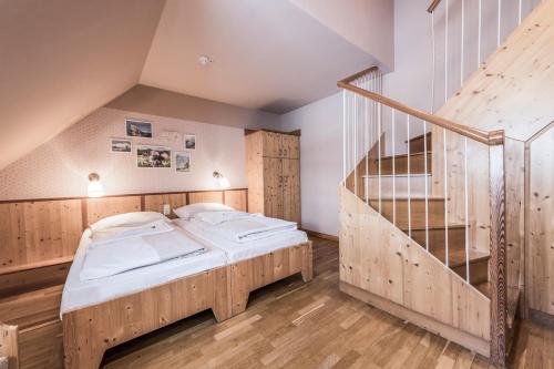 a bedroom with a bed and a staircase at JUFA Hotel Grundlsee in Grundlsee