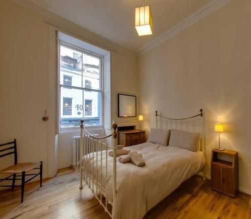 エディンバラにあるALTIDO Spacious 2Bed in Heart of Old Town - Diagon Alleyのベッドルーム(白いベッド1台、窓付)