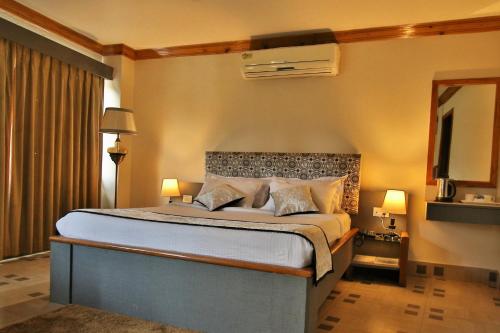 a bedroom with a large bed and a television at Hotel Gateway Shillong in Shillong