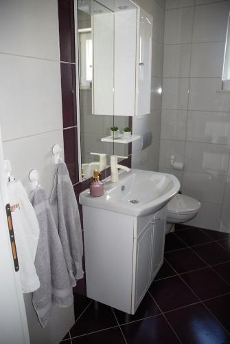 a white bathroom with a sink and a toilet at Villa Isabella in Sevid