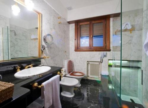 a bathroom with a sink and a toilet and a shower at Los Nobles Hostal de Bosque in Mar del Plata