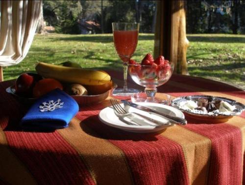 a table with a plate of food on a table at Los Nobles Hostal de Bosque in Mar del Plata