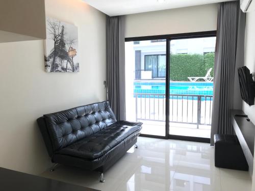 um sofá de couro preto numa sala de estar com piscina em V.O.P Suite em Chaweng