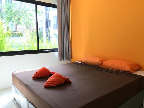2 almohadas en una cama en una habitación con ventana en V.O.P Suite, en Chaweng
