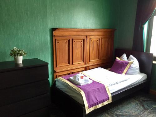 a small bedroom with a bed with a wooden headboard at Ferienwohnung Alabama in Lutherstadt Wittenberg