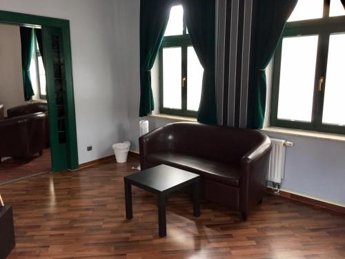 a living room with a leather couch and a table at Ferienwohnung Alabama in Lutherstadt Wittenberg