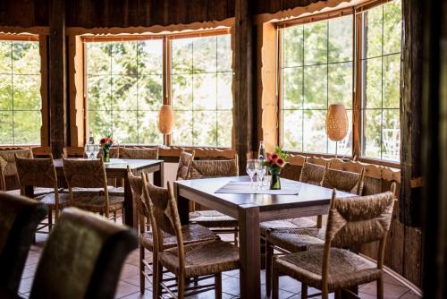 a dining room with tables and chairs and windows at Pension Almhof Baumgarten in Bad Reichenhall