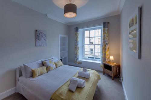 a bedroom with a large bed with towels on it at JOIVY Stylish Apt in Trendy New Town Location in Edinburgh