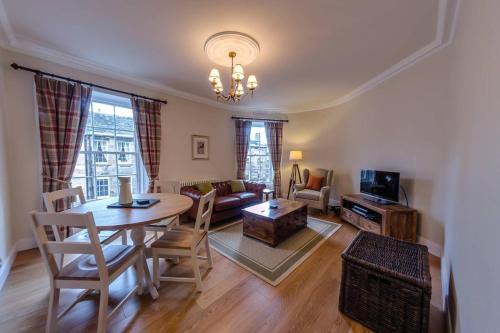a living room with a table and a couch at JOIVY Stylish Apt in Trendy New Town Location in Edinburgh