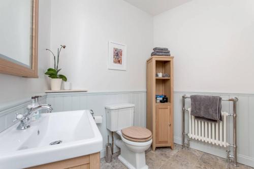 a white bathroom with a toilet and a sink at JOIVY Stylish Apt in Trendy New Town Location in Edinburgh