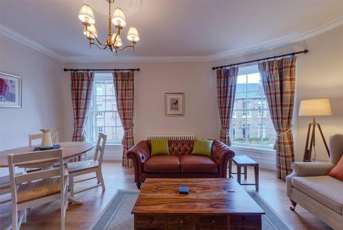 a living room with a couch and a table at JOIVY Stylish Apt in Trendy New Town Location in Edinburgh