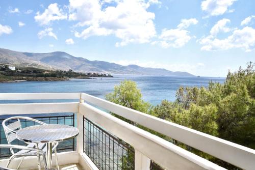 a balcony with a table and a view of the water at Karystion Hotel in Karistos