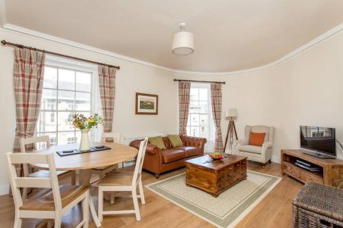 a living room with a table and a couch at JOIVY Stylish Apt in Trendy New Town Location in Edinburgh