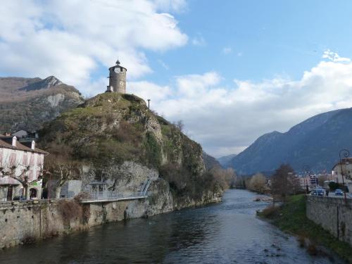 a river with a lighthouse on top of a mountain at Hôtel Le Bellevue in Tarascon-sur-Ariège