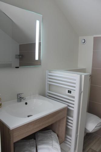 a white bathroom with a sink and a mirror at Les chambres d'hôtes du Fil Rouge in Armentières