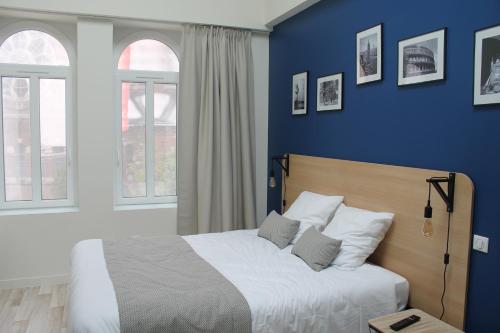 Un pat sau paturi într-o cameră la Les chambres d'hôtes du Fil Rouge