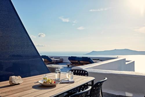 a table with a bowl of fruit on a balcony at Homeric Poems in Fira