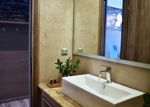 a bathroom with a tub, sink, and mirror at Karystion Hotel in Karistos