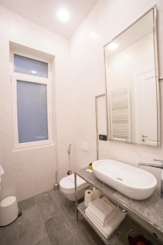 a white bathroom with a sink and a toilet at Premium Apartments in Sarajevo