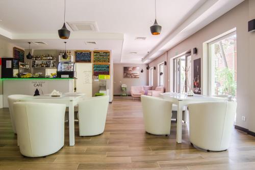 a restaurant with white tables and white chairs at Dwie Sosny z sauną, Sun & Snow in Ustronie Morskie
