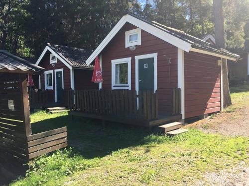 Stockholm Ängby Camping في ستوكهولم: منزل صغير مع سور في ساحة