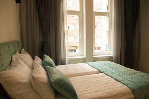 a bed with pillows in front of a window at Premium Apartments in Sarajevo