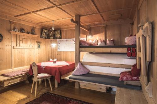 a room with a table and two bunk beds at Haus Tirol in Molini di Tures