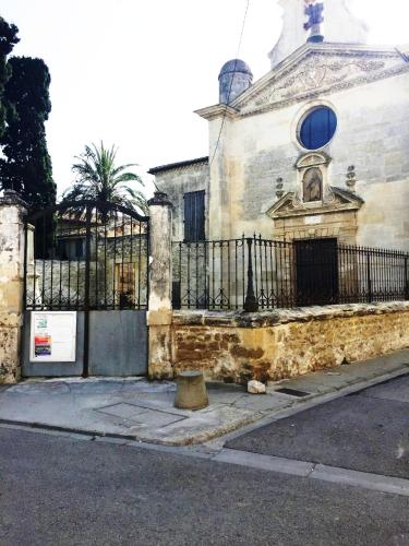 an old building with a black fence next to a street at Au Cœur des Remparts in Aigues-Mortes