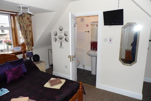 a living room with a bed and a bathroom at Torridon Guest House in Inverness