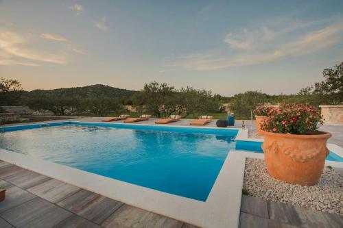 a swimming pool with blue water in a yard at Villa Red Hacienda with Pool in Vodice