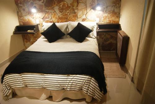 a bedroom with a large bed with two pillows at Posada Del Fin Del Mundo in Ushuaia