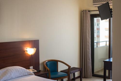 En eller flere senge i et værelse på Hotel Avenida Praia