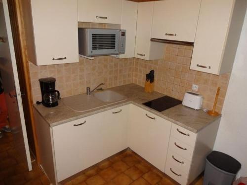une petite cuisine avec un évier et un micro-ondes dans l'établissement 8 rue du bac, à Font-Romeu