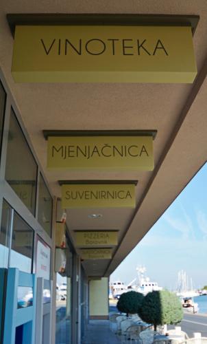 a building with signs on the side of it at Hotel Borovnik in Tisno