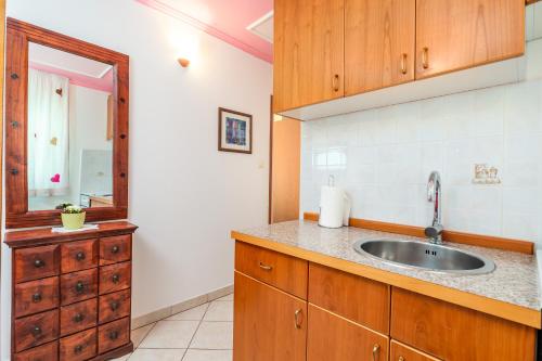a kitchen with a sink and a mirror at Apartments Patricia in Baška
