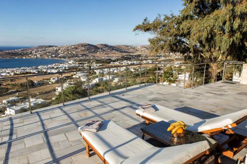 a patio with chairs and a table with bananas on it at Amazing Sea View Villa in Parikia