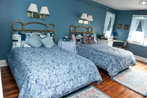 2 camas en un dormitorio con paredes azules en Cedars & Beeches Bed & Breakfast, en Long Branch